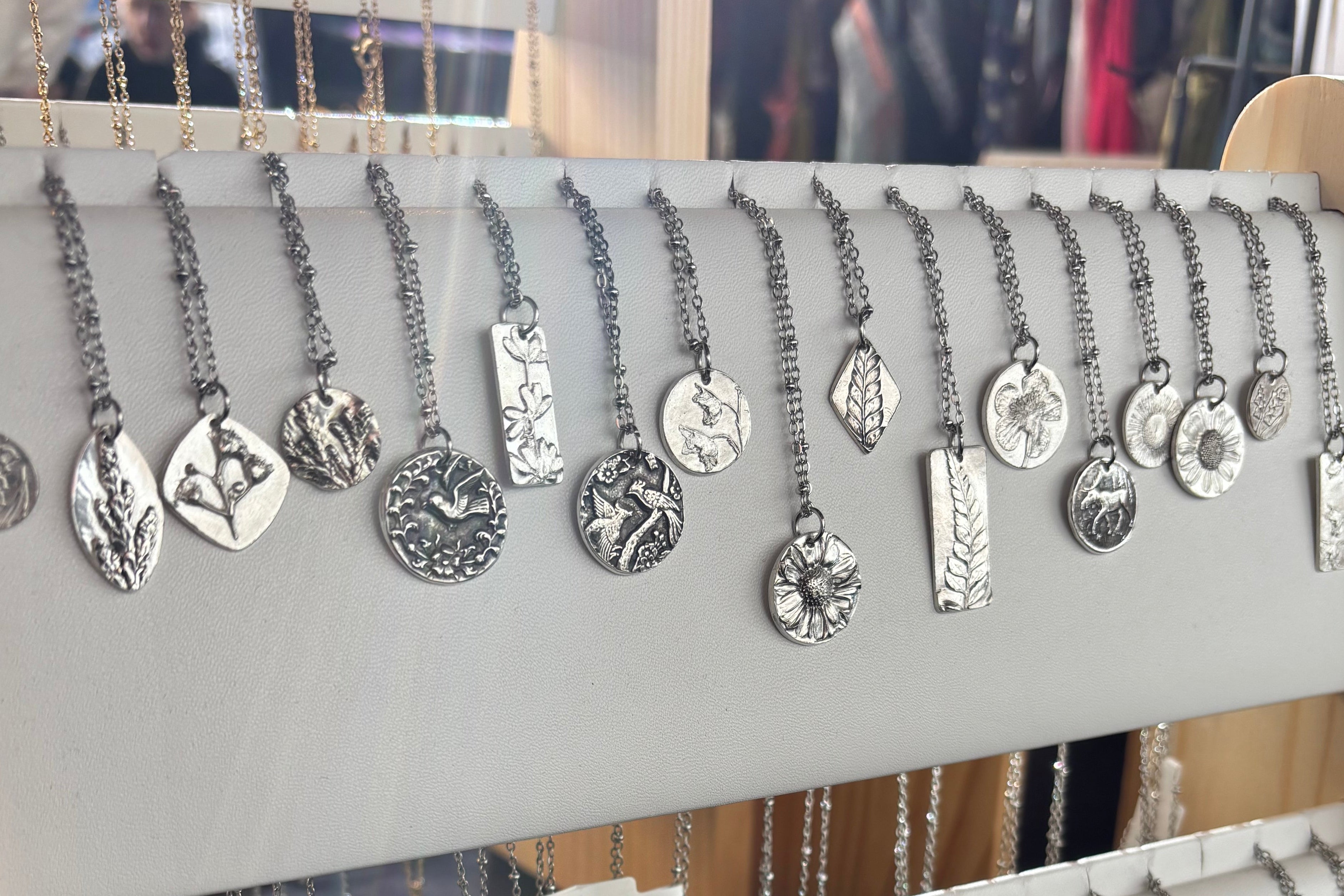 Silver jewelry on display with a neutral background